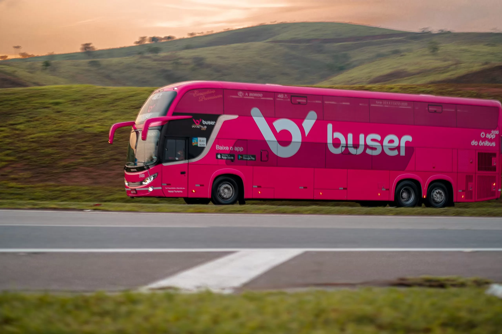 Ônibus rosa da Buser trafegando na rodovia - Como pegar Buser em Sete Lagoas